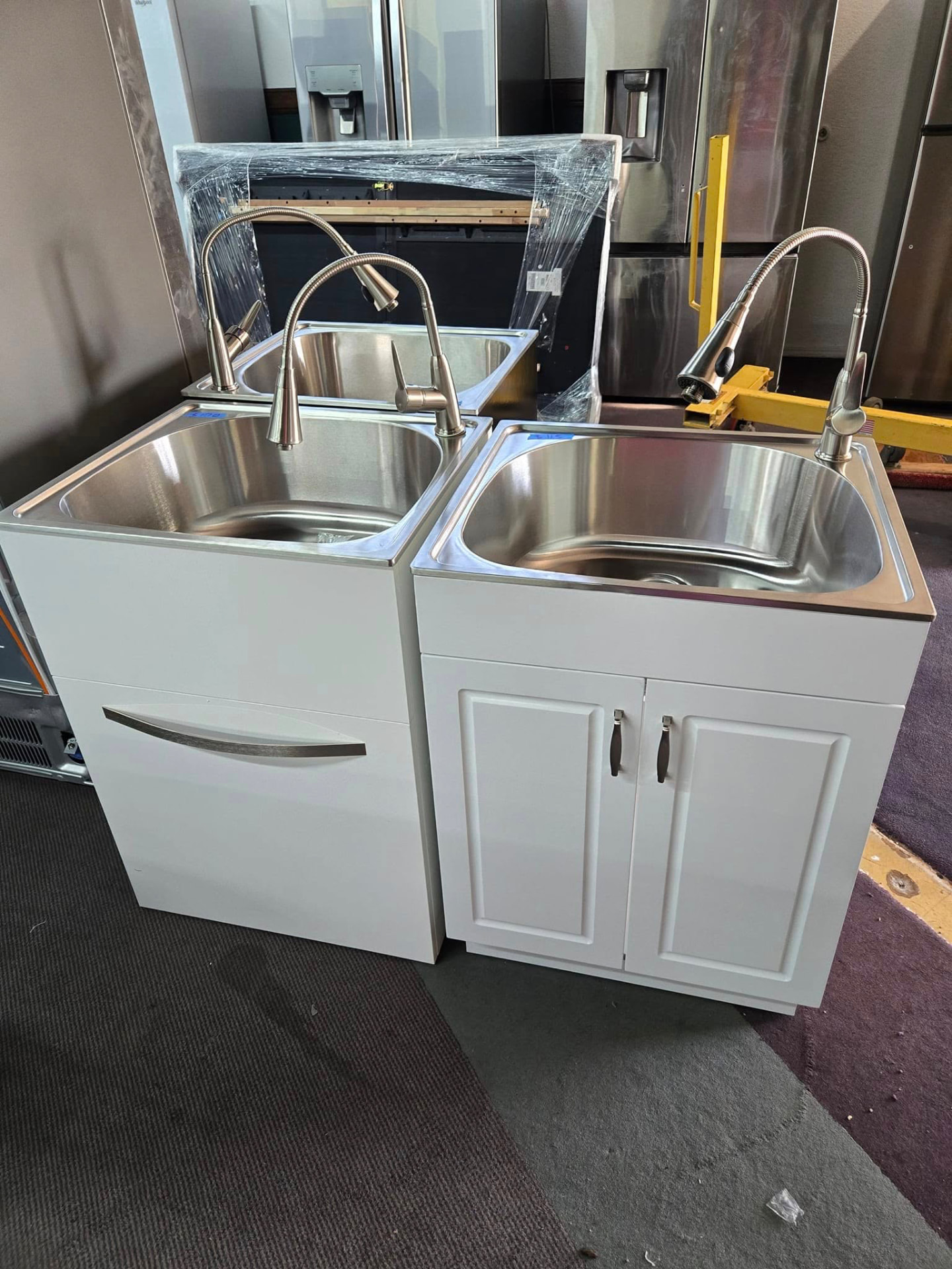 White utility sink cabinets with stainless basins on the floor