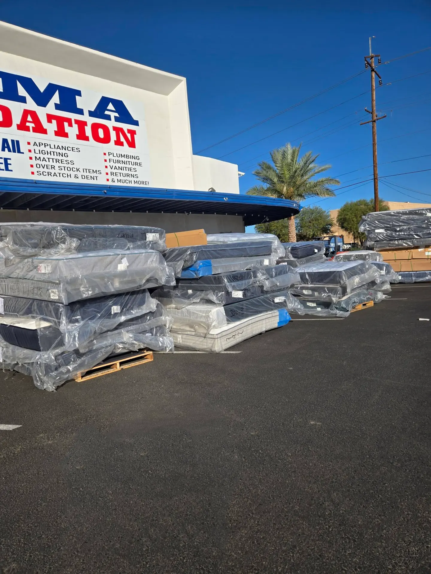 Pallets of wrapped mattresses outside the Yuma Liquidation storefront