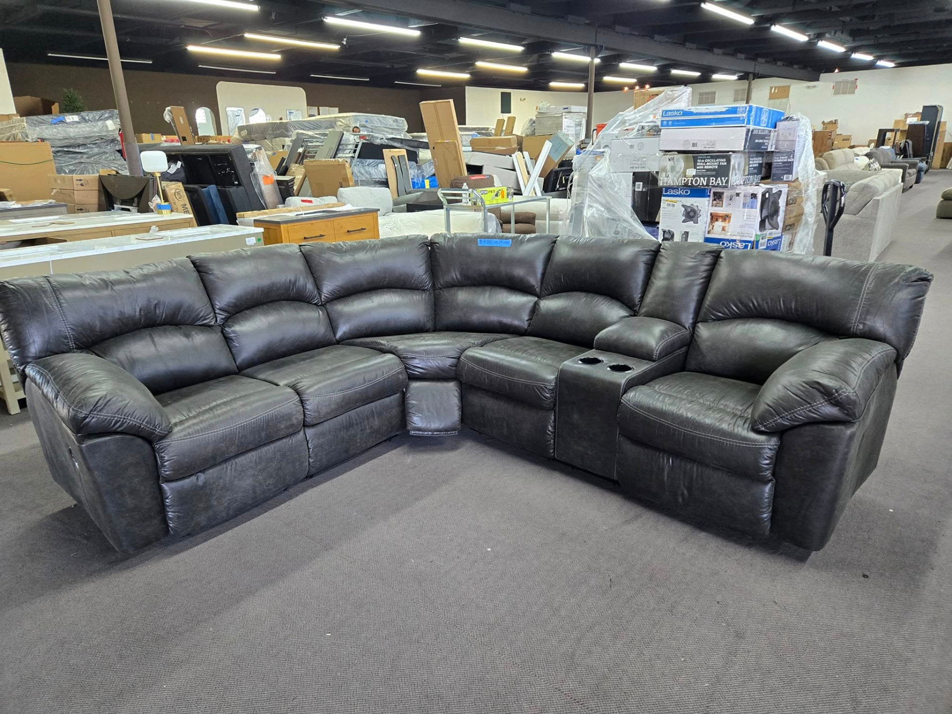 Dark grey reclining sectional with cup holders in the warehouse